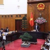 Премьер-министр Фам Минь Тьинь выступает на онлайн-встрече с официальными лицами Туенкуанг в Ханое 25 декабря. (Фото: ВИА)