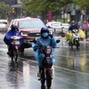 Люди в теплой одежде едут под дождем (Фото: ВИА) 
