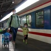 Женщина и ее ребенок готовятся сесть на поезд на вокзале Сайгона в Хошимине, чтобы вернуться домой. (Фото: ВИА)