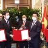 Президент Нгуен Суан Фук стал свидетелем заключения соглашений о сотрудничестве между вьетнамскими предприятиями и Sembcorp Group. (Фото: ВИА)