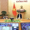 Премьер-министр Фам Минь Тьинь (стоит) председательствует на национальной телеконференции 5 апреля. (Фото: ВИА)