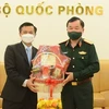 Заместитель министра национальной обороны генерал-полковник Хоанг Суан Чиен (справа) вручает подарки заместителю посла Лаоса во Вьетнаме Чантафону Хамманичану по случаю лаосского праздника Бунпимай. (Фото: ВИА)