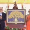 Президент Нгуен Суан Фук вручает сувениры Кхмерской буддийской академии Тхеравады. (Фото: Тонг Нят/ВИА)