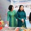 Вице-президент страны Во Тхи Ань Суан (в центре) посещает выставочный стенд печатных изданий ВИА. (Фото: ВИА)