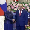 Президент Вьетнама Нгуен Суан Фук (справа) пожимает руку вице-президенту Лаоса Пани Ятоу (Фото: ВИА)