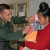 Военный врач осматривает ребенка в сельской местности. (Фото: ВИА)