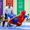 Вьетнамский мастер ушу Буй Чыонг Жанг (в синем) побеждает Джуманту из Индонезии и одерживает победу в саньда в категории 60 кг среди мужчин 15 мая. (Фото: ВИА)
