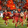 Женская сборная Вьетнама по футболу держала национальный флаг и пробежала по стадиону Камфа, отпразднуя золотую медаль на 31-х Играх Юго-Восточной Азии. (Фото: Vietnam+)