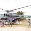 Военнослужащие заносят жителя в вертолет в рамках учений. (Фото: ВИА) 