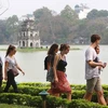 Иностранные туристы возле озера Хоанкием в центре Ханоя. (Фото: ВИА)