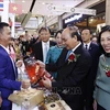 Президент Нгуен Суан Фук посещает вьетнамские стенды. (Фото: ВИА)