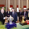 Председатель Национального сборания Выонг Динь Хюэ и король Нородом Сиамони обмениваются подарками. (Фото: ВИА)
