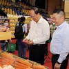 Г-н Нгуен Хо Хай (справа), заместитель секретаря горкома партии Хошимина посетил стенд «Супермаркет 0 донг». (Фото: ВИА)