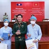 Генерал-майор, доцент, доктор Нгуен Суан Киен, директор Вьетнамского военного госпиталя № 103, вручил подарки двум лаосским пациентам, которым успешно пересадили почку. (Фото: ВИА)