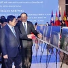 Премьер-министр Фам Минь Тьинь и премьер-министр Лаоса Сонексай Сипхандоне посещают фотогалерею. (Фото: ВИА)