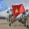 Вьетнамские военные медики поднимают два флага ООН и Вьетнама в международном аэропорту Джуба, приступая к выполнению миротворческой миссии ООН в Южном Судане. (Фото: ВИА)