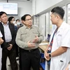 Премьер-министр Фам Минь Тьинь инспектирует и разговаривает с врачами и медсестрами в больнице Батьмай. (Фото: ВИА)