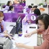 Клиенты совершают транзакции в коммерческом акционерном банке Tien Phong (TPBank). (Фото: hanoimoi.com.vn)