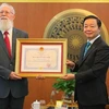Заместитель премьер-министра и министр природных ресурсов и окружающей среды Чан Хонг Ха наградил доктора Майкла Г. Парсонса медалью Дружбы. (Фото: ВИА)