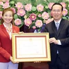 Президент Во Ван Тхыонг вручает Орден Труда второй степени легкоатлетке Нгуен Тхи Оань, которая завоевала 4 золотые медали на SEA Games 32. (Фото: ВИА)