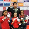 Спортсменка Чинь Тхи Бить Ны (в центре) завоевала золотую медаль, побив рекорд Паралимпийских игр АСЕАН в плавании на дистании 100 м. вольным стилем категории инвалидности S6. (Фото: ВИА)