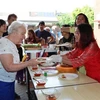 Бельгийская женщина наслаждается вьетнамской едой на мероприятии. (Фото: ВИA)