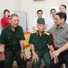 Премьер-министр Фам Минь Тьинь (справа) посещает больных солдат и инвалидов войны в Центре по уходу за инвалидами войны «Ньёкуан» в провинции Ниньбинь. (Фото: ВИA)
