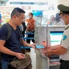 Пассажир использует VNeID на стойке безопасности международного аэропорта Нойбай. (Фото: VietnamPlus) 