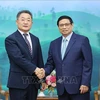 Премьер-министр Фам Минь Тьинь (справа) и вице-президент и генеральный директор корпорации Amkor Technology Чжи Ронг-Рип (Фото: ВИA)