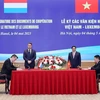 Премьер-министр Вьетнама Фам Минь Тьинь (второй справа) и его люксембургский коллега Ксавье Беттель (в центре) стали свидетелями подписания соглашения о стратегическом партнерстве в области "зеленого" финансирования в Ханое 4 мая 2023 года. (Фото: ВИA)