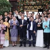 Премьер-министр Фам Минь Тьинь, премьер-министр Сонексай Сипхандон, их жены и вьетнамские и лаосские студенты позируют для фото в Ханое 7 января (Фото: ВИA)