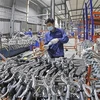 Рабочие производят велосипеды на заводе акционерной компании Тхонгнят в Ханое. (Фото: ВИA)