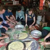  Иностранные туристы пробуют делать пирог Чынг (Фото: ВИA)