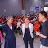 Сенатор Дженни Макалистер (в белом), помощник министра по вопросам изменения климата и энергетики Австралии, посещает завод Dat Bike. (Фото: ВИA)
