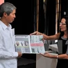 亚—非—拉三大洲团结组织秘书长Lourdes Cervantes Vasquez（右）向越南驻古大使杨明赠送越古双边关系的海报