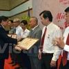 越南驻柬埔寨大使馆临时代办阮卓全向旅居柬埔寨越南人组织和个人颁发奖状