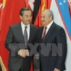 乌兹别克斯坦外长阿卜杜勒阿齐兹·卡米洛夫（右）与中国外长王毅（左）