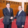 越南政府总理阮春福（右）与泰国副总理塔纳萨（左）亲切握手（图片来源：越通社）