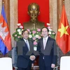 国家主席陈大光（右）与柬埔寨国务兼外交国际合作部大臣布拉索昆亲切握手（图片来源：越通社）
