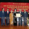 国会主席阮氏金银和旅居老挝越南人代表合影（图片来源：越通社）