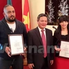 越南驻阿尔及利亚大使向阿尔及利亚记者奥吴拉·拉扎和利安德·阿巴达颁发奖状（图片来源：越通社） 