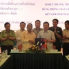 越南清化省农业与农村发展厅代表同老挝华潘省农林业厅代表签署合作文件（图片来源：baothanhhoa.vn)