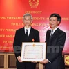 越南驻泰国大使​阮必成向泰国外交部副常任秘书、前泰国驻越大使潘雅拉克​授予越南国家主席的友谊勋章 （图片来源：越通社）
