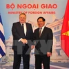 越南政府副总理兼外交部长范平明与希腊外交长尼科斯亲切握手（图片来源：越通社
