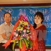 阮孟强参赞向越南驻柬埔寨妇女协会代表送鲜花（图片来源：越通社）