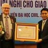 河内市人委会领导向乔尔·勒罗伊教授（左）授予越南国家主席的友谊勋章（图片来源：baomoi.com)