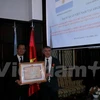 越南驻阿根廷大使阮廷操（左）向克劳迪奥·古铁雷斯授予友谊勋章。（图片来源：越通社）