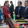 越南驻阿尔及利亚大使范国柱（右）参观越南企业的展位（图片来源：越通社）