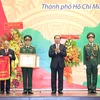 越南国家主席陈大光向越共南方局统一机要委员会授予人民武装力量英雄称号。（图片来源：越通社）