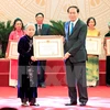 陈大光主席​向越通社战地记者、烈士梁义勇​家属代表​颁发胡志明奖。